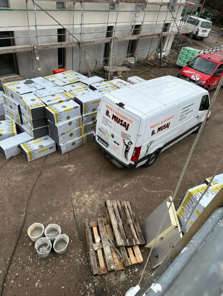 Ansicht von oben, eines aufgestellten Gerüsts mit Firmenfahrzeug und Paletten-Ware davor.