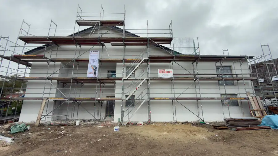 Nahaufnahme eines aufgestellten Gerüsts an einer Außenwand, während der Außenputz arbeiten.