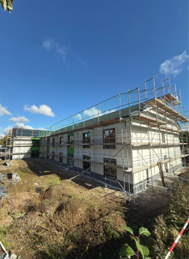 Aufgestelltes Gerüst an einer Außenwand, während der Außenputz arbeiten.