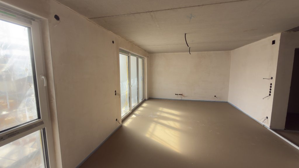 Fertige Gipsarbeiten eines hellen und lichtdurchfluteten Innenraumes mit großen Fenstern.